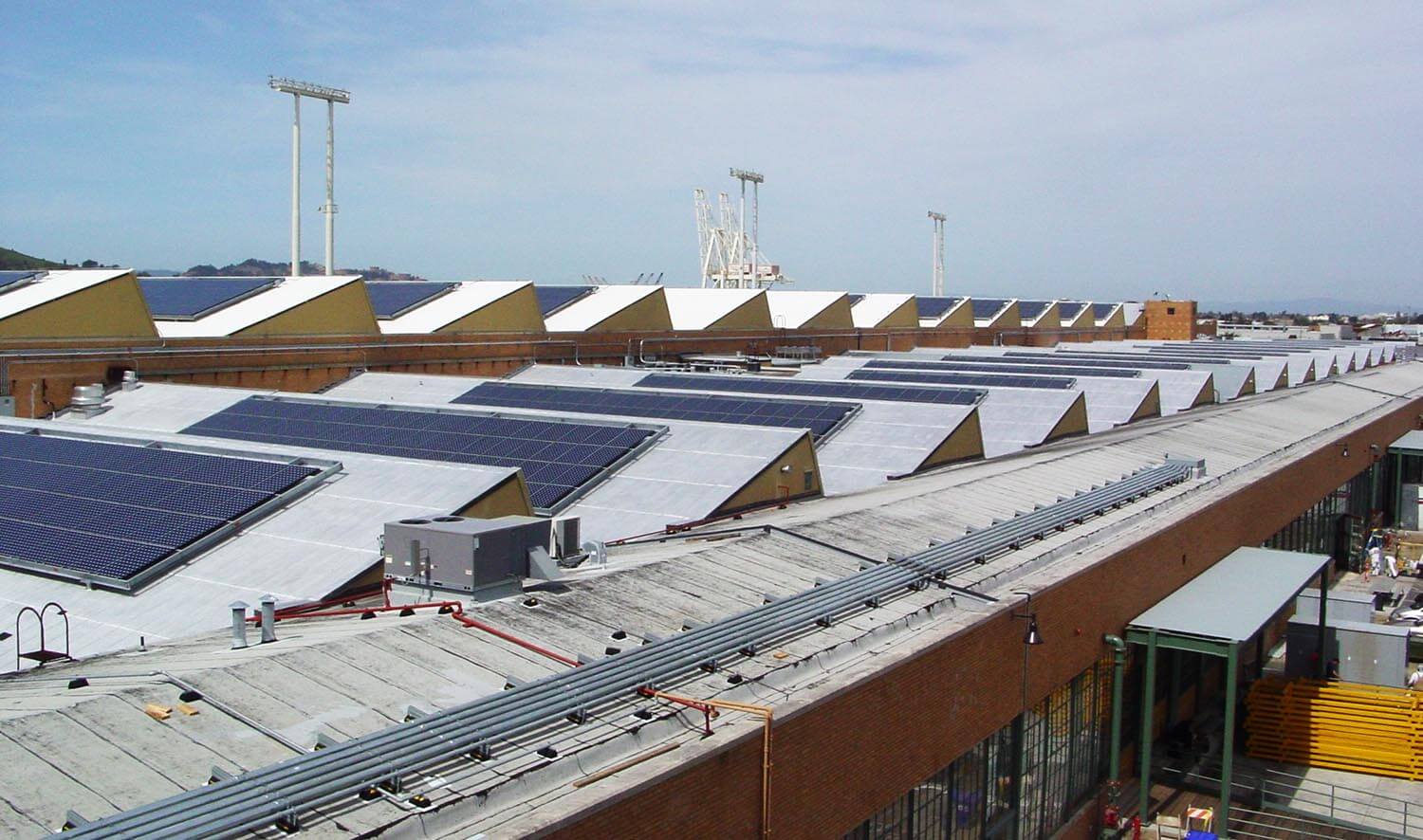 Exterior view of Ford Assembly Building, Richmond, CA showing sawtooth roof pattern and solar panels